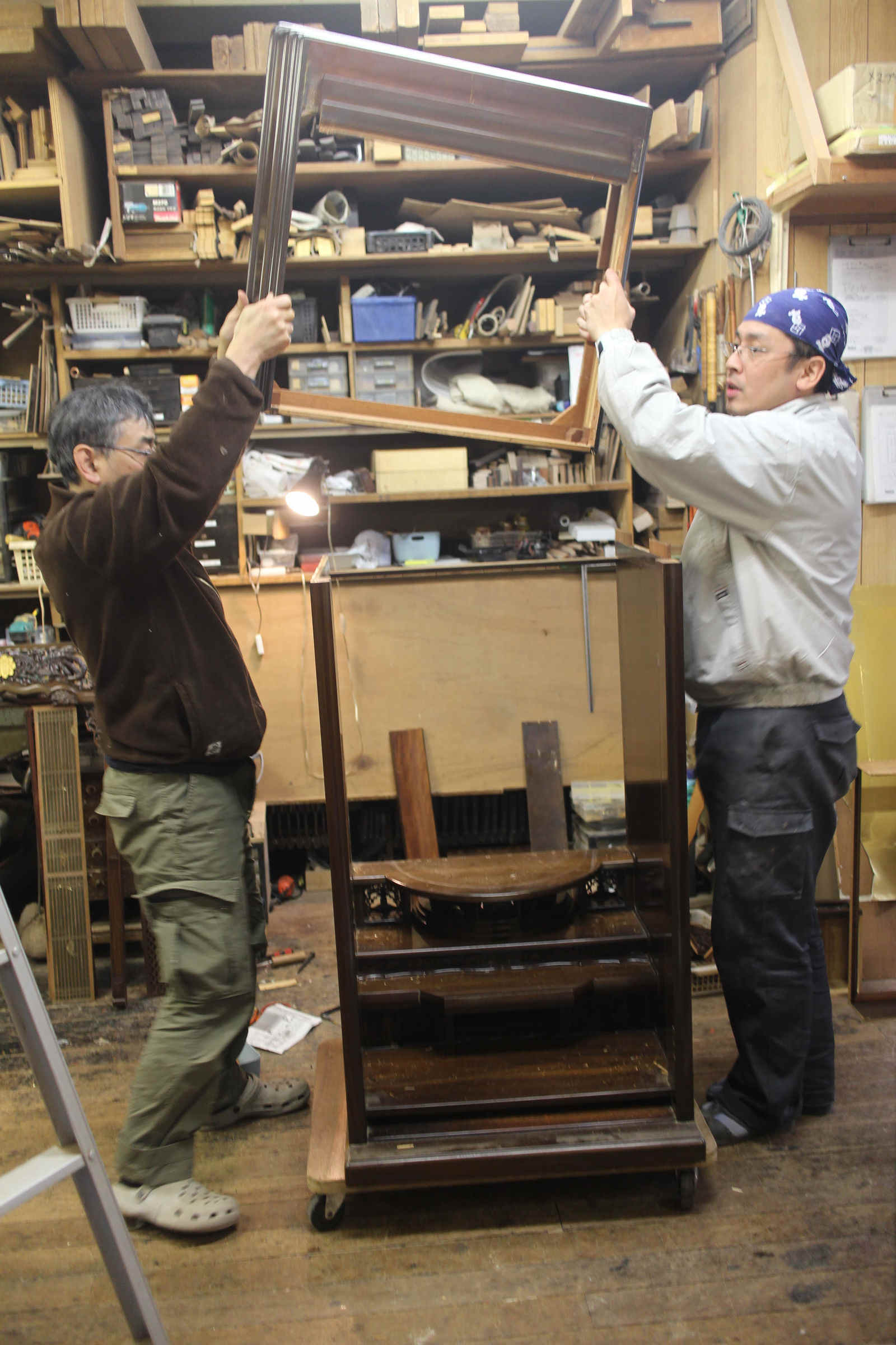 二人がかりで仏壇の部材を運ぶ職人