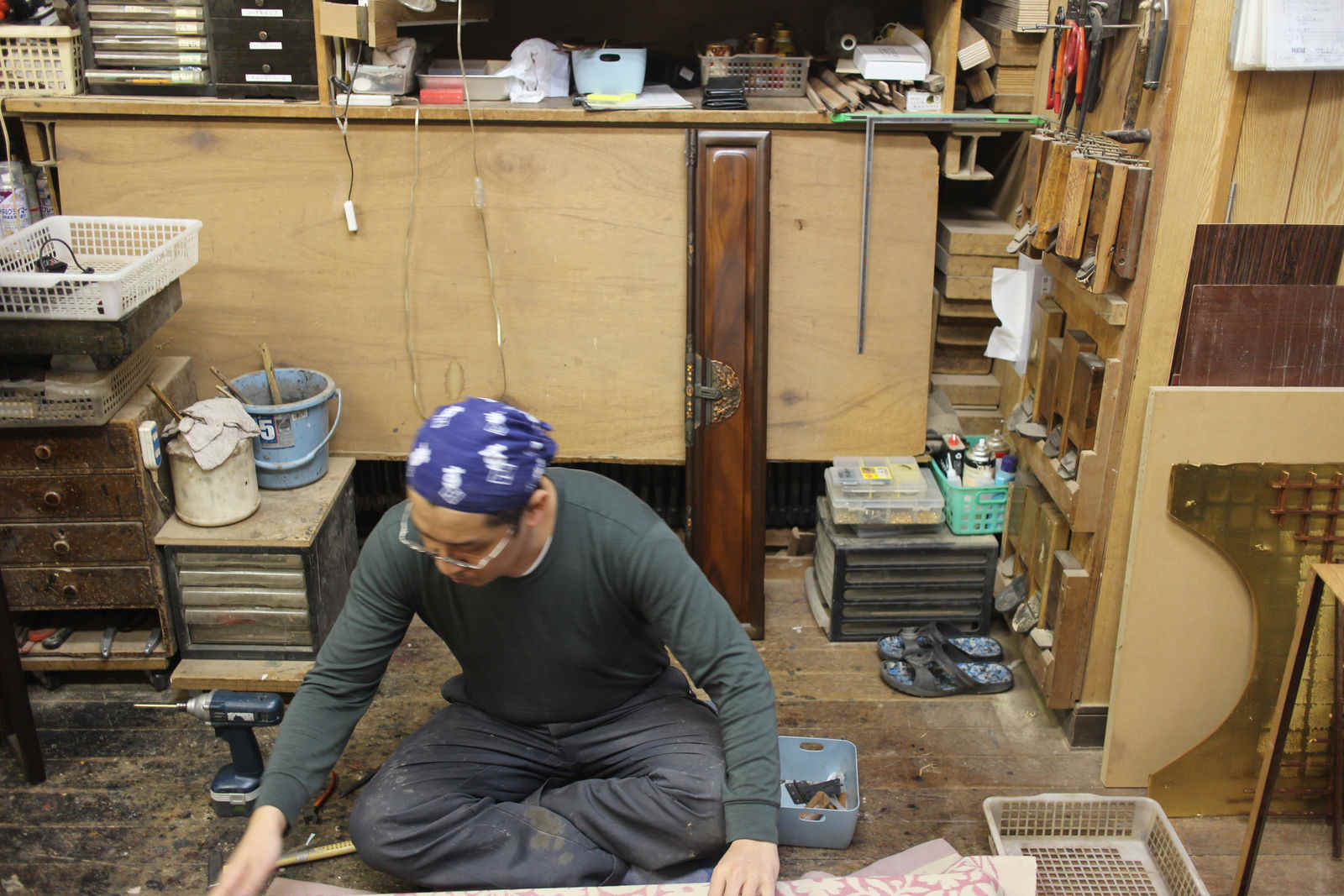 道具に囲まれた工房で作業する職人